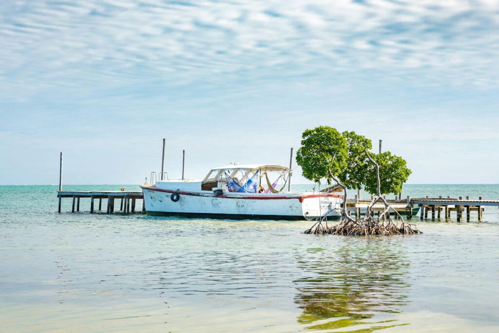 Boat moored on small wooden pontoon over shallow blue waters