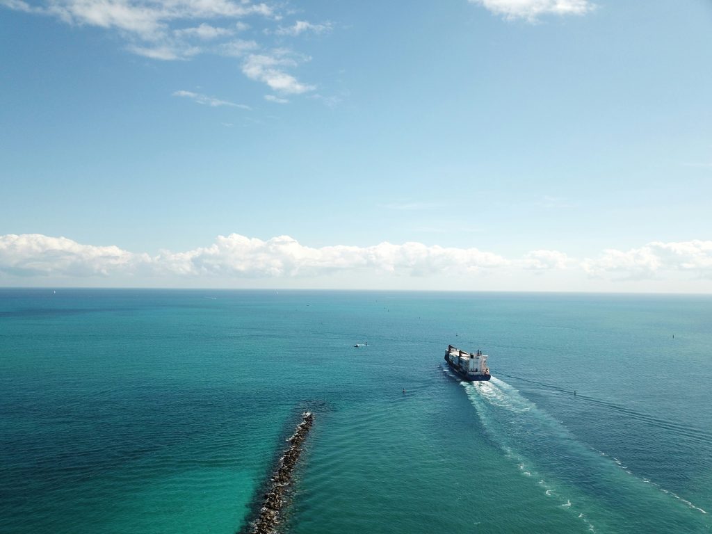 Aerial picture of a cargo ship departing from belizean waters moving towards open waters